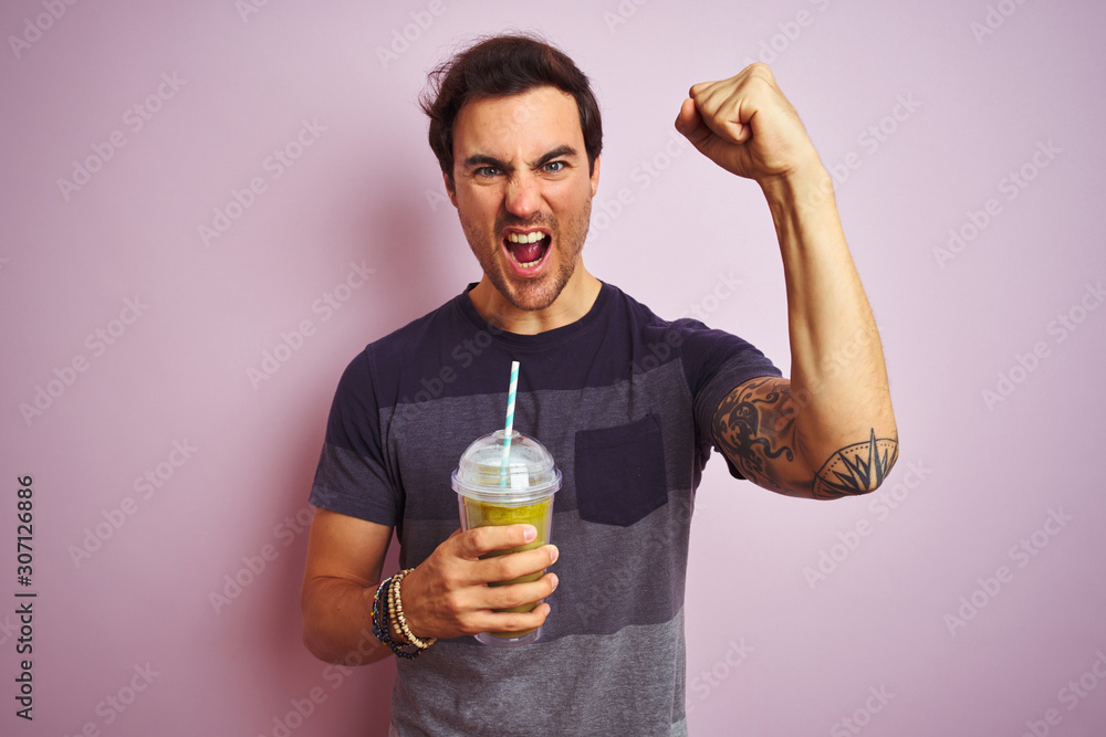 Sticker Young handsome man with tattoo drinking smoothie standing over isolated pink background annoyed and frustrated shouting with anger, crazy and yelling with raised hand, anger concept