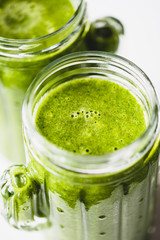 Fresh green smoothies in glass jars on white background, Superfood, detox and healthy eating concept.