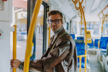 Handsome stylish man standing inside the tram