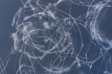 An abstract pattern. The icy surface of the reservoir is indented by traces of skates. The view...