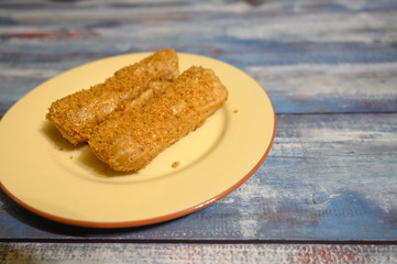 Two cakes on a plate on a wooden background.