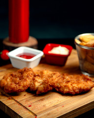 chicken nuggets on a wooden board and french fries