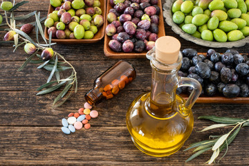 Many types of olive like green & black and olive oil at the rustic wooden table