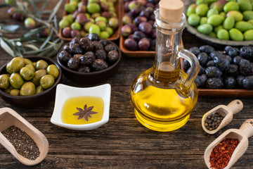 Many types of olive like green & black and olive oil at the rustic wooden table