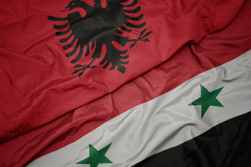 waving colorful flag of syria and national flag of albania.