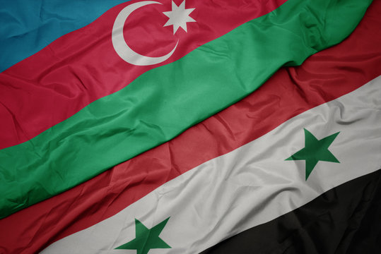 waving colorful flag of syria and national flag of azerbaijan.