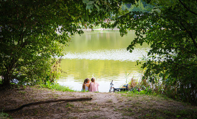 Children have a rest on the river bank. Summer time. Landscape
