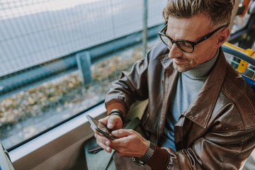 Attractive man using cellphone during bus ride