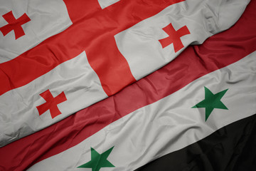 waving colorful flag of syria and national flag of georgia.