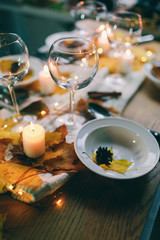 served table with decorations, candles and autumn leaves Table served for autumn dinner in living room