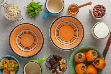 Breakfast ingredients with cereal, yogurt, nuts and fruits. Concrete gray background. Healthy eating