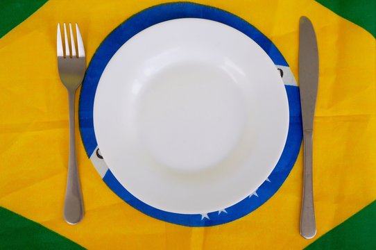 Plate and cutlery on Brazilian flag. Brazilian food concept. Cuisine of Brazil.