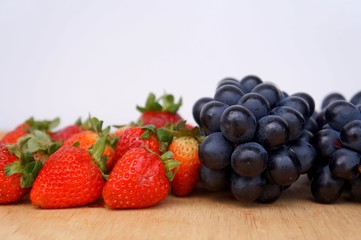 Strawberries and dark blue grapes. Seedless grapes.