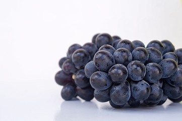 Dark blue grapes on white background. Seedless grapes.