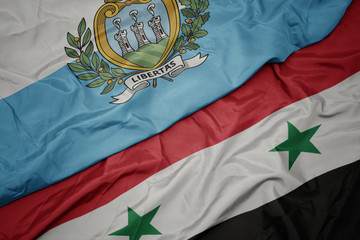 waving colorful flag of syria and national flag of san marino.