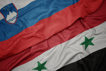 waving colorful flag of syria and national flag of slovenia.