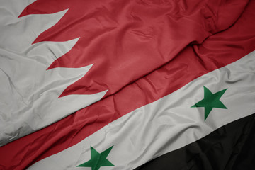 waving colorful flag of syria and national flag of bahrain.