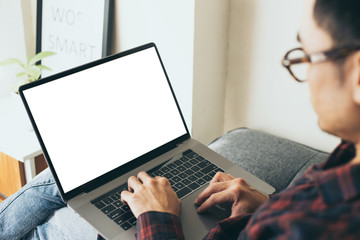 mockup image blank screen computer with blank white background for advertising text,hand man using laptop contact business search information on desk at home office.marketing and creative design