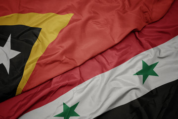 waving colorful flag of syria and national flag of east timor.