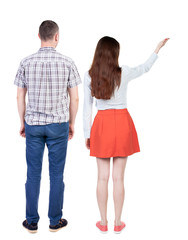 Back view of a stylish couple pointing.