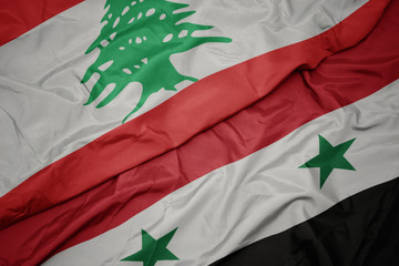 waving colorful flag of syria and national flag of lebanon.