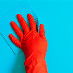 Employee hand in rubber protective glove with micro fiber cloth wiping wall from dust. Commercial cleaning company concept