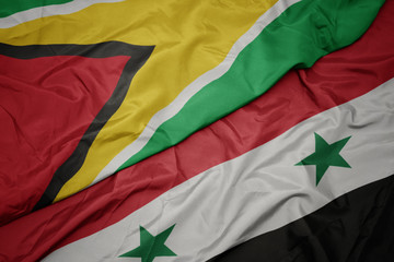 waving colorful flag of syria and national flag of guyana.