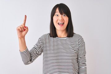 Young beautiful chinese woman wearing black striped t-shirt over isolated white background pointing finger up with successful idea. Exited and happy. Number one.
