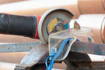An element of a detachable abrasive disk stuck in goggles while working with a catch grinder