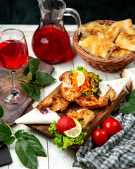 chicken tobacco on a wooden board and a glass of compote
