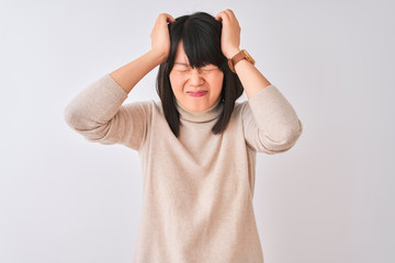 Young beautiful chinese woman wearing turtleneck sweater over isolated white background suffering from headache desperate and stressed because pain and migraine. Hands on head.