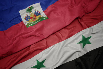 waving colorful flag of syria and national flag of haiti.