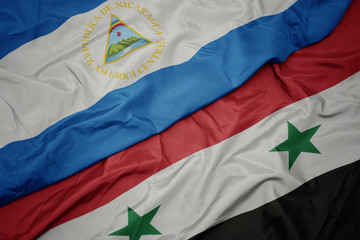 Fototapeta premium waving colorful flag of syria and national flag of nicaragua.