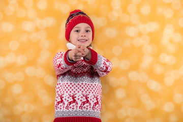 Little girl in winter look pointing her finger at you