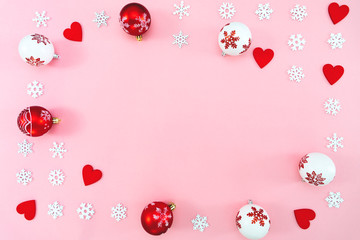 Christmas composition. Christmas balls, red heart and snowflakes decorations on pink background. Flat lay, top view, copy space