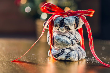 Three Christmas cookies gift on a golden colored table with bokeh lights, close up, macro photography