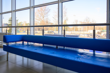 Interior concept of a modern urban building. Photo of a blue sofa in the lobby of a public building.