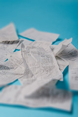 Pile of shopping receipts on blue background