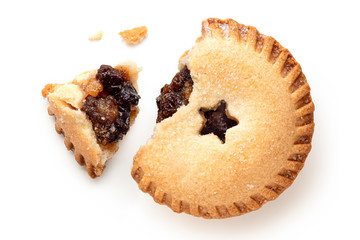 Broken open traditional british christmas mince pie with fruit filling isolated on white. Top view.