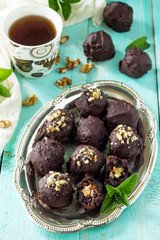 Homemade prune sweets, healthy food. Prune balls in chocolate with hazelnut filling.