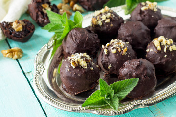 Homemade prune sweets close-up, healthy food. Prune balls in chocolate with hazelnut filling.