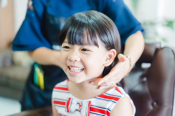 Asian little girl haircut. hairdresser, beauty salon.Cute little asian girl in hairdressing salon.