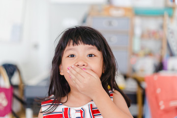 Shy girl close her mouth when she have decayed tooth or broken tooth at home.Children's mouth and...