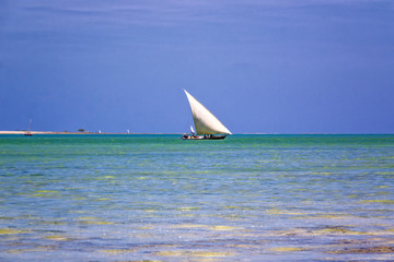Old sailing boat sailing in high tide, coast of Zanzibar