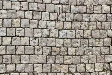 An old stoneblock pavement cobbled with white square stone blocks