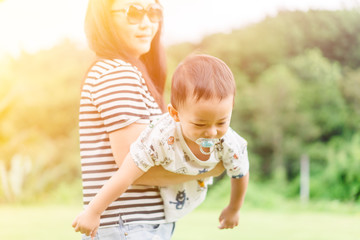 Fototapeta premium Happy loving family.Asian mother and toddler boy child playing fly and have fun in the park at home.