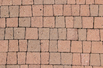 Sidewalk paved with irregular trapeziform orange tiles