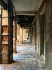 Sidewalk lined with columns in an old street of Venice