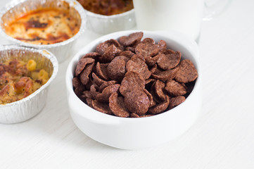 Bowl of cereals, lasagna and milk for breakfast on white background