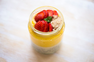 Chia pudding and mango smoothie with strawberries on the wood table